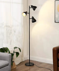 Three Adjustable Rotating Heads Go-To Tree Floor Lamp In Black Industrial Rustic Style next to sofa and plant in living room.