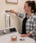 Woman using Heavy Duty Rubberized Waterproof Sealant Paste In Bright White Half Quart Tub to seal around a duct in laundry room.