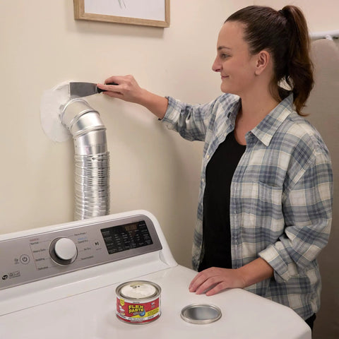 Woman using Heavy Duty Rubberized Waterproof Sealant Paste In Bright White Half Quart Tub to seal around a duct in laundry room.