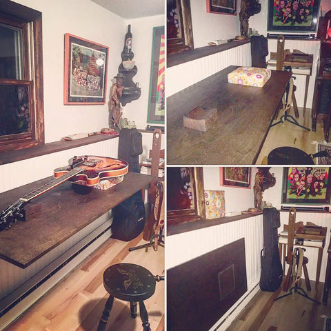 Rock Solid 24 Inch Black Folding Shelf Brackets Heavy Duty Wall Mount Supports Built Tough For Up To 440 Pounds space-saving table with guitar and decor.