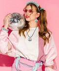 Woman in 70s attire holding disco ball, promoting 27 Piece Disco Ball Cake Toppers Set With Retro Turntable Dancers And Four Size Options 0.79 In 1.18 In 1.57 In And 1.97 In For 70s Disco Theme Parties Groovy Party Decor That Elevates Any Cake.