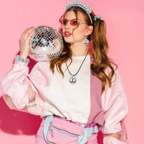 Woman in 70s attire holding disco ball, promoting 27 Piece Disco Ball Cake Toppers Set With Retro Turntable Dancers And Four Size Options 0.79 In 1.18 In 1.57 In And 1.97 In For 70s Disco Theme Parties Groovy Party Decor That Elevates Any Cake.