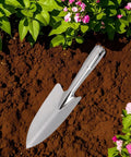 Stainless Steel Garden Trowel And Hand Shovel With Pro Grade Measurement Marks in soil with pink flowers around