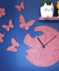 Pink glitter butterfly wall art and clock on blue wall next to shelf, not related to Glitter Pink Easy Peel And Stick Contact Paper.