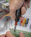 Person using 11 Piece Convertible Nutdriver Set With Piggyback Torque Amplifier Handle Color Coded Grips on circuit board