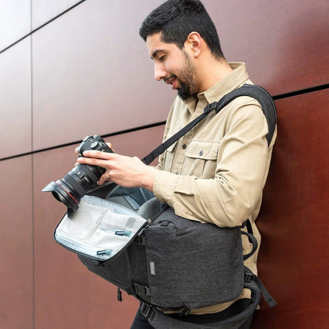 Urban Access 13 Side Loading Camera Backpack With Quick Access Side Panels And Rear Panel Entry 13 Inch Laptop Pocket worn by photographer