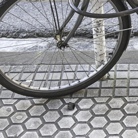 Aluminum Alloy Bicycle Axle Cap for Front and Rear Wheel Hubs Easy Install Hub Nut Replacement alongside a bike wheel on pavement