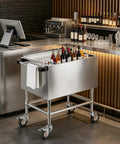 Ice Bin Cart With Wheels For Outdoor Parties And Patio Events A Portable Insulated Cooler Cart On The Go With Sliding Lid Removable Handle And Drain Pipe Large Capacity Ice Storage Bin For Easy Party Prep in a modern bar setting with beverages