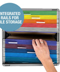 Hand accessing colorful file folders in a storage crate with integrated rails for file organization.
