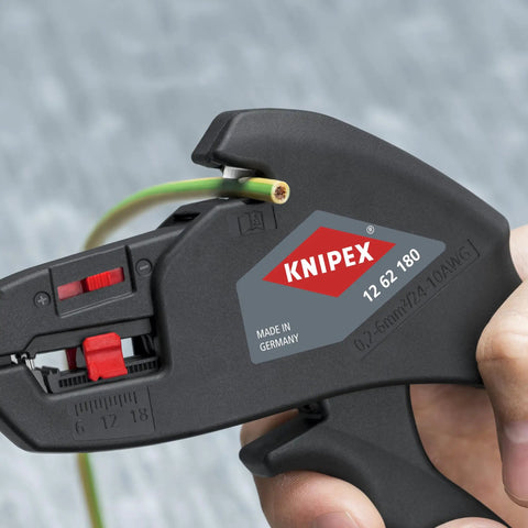 Hand using insulation strippers for wires compact automatic cable stripping tool on green cable, adjusts 0.2 to 6 mm²
