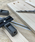 Twin Pocket Hole Jig Set With Adjustable Base And Magnetic Quick Adjust System for woodworking on a wooden board with drill bit.