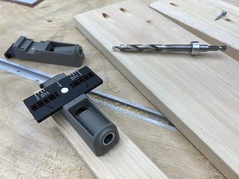 Twin Pocket Hole Jig Set With Adjustable Base And Magnetic Quick Adjust System for woodworking on a wooden board with drill bit.