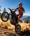Badass Heavy Duty 5000 Watt Electric Dirt Bike For Adults And Teens performing a wheelie on a dirt trail with dust clouds.