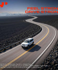 Vehicle driving on a winding road with mountains in the background, showcasing performance and control.