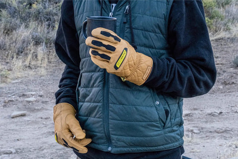 Person wearing Ranchworx Winter Work Gloves RWDI Premium Leather Insulated Cold Weather Gear holding cup on outdoor trail.