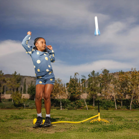 Child playing with Glow In The Dark Rocket Launcher Kit For Kids With Four Soft Foam Rockets Backyard Blast Off STEM Toy outdoors.