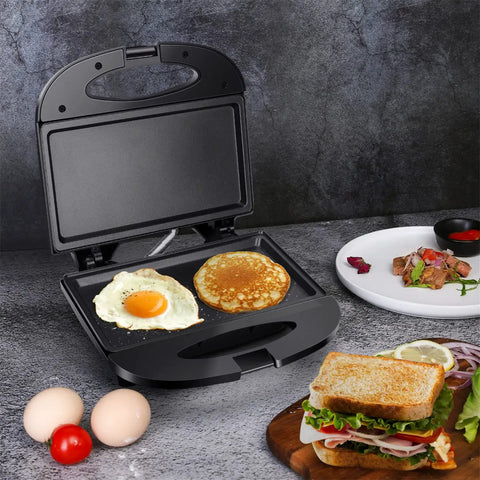 Aigostar Flat Sandwich Maker With Nonstick Deep Grill Surface, Black. Eggs and pancakes cooking on the nonstick plates.