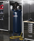 Heavy Duty Sixty Gallon Two Stage Air Compressor in workshop, showcasing oil lubricated cast iron pump and sturdy design.