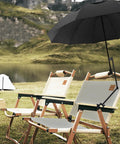 A Zero Stress UV Defense This Upf Fifty Plus Golf Umbrella packs a heavy duty clamp over black deck chairs by a lake.