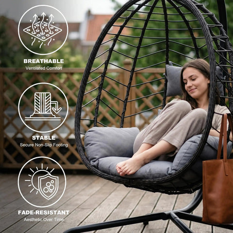 Woman relaxing in a grey Hanging Egg Chair With Stand for Indoor And Outdoor Relaxation Cozy Wicker Hammock Lounge Chair with Cushion