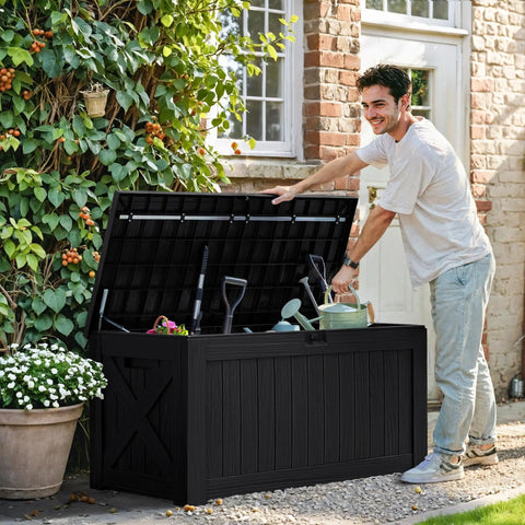 Man using 120 Gallon Outdoor Deck Box Heavy Duty Resin Construction Weatherproof Lockable Storage For Patio Furniture Garden Tools