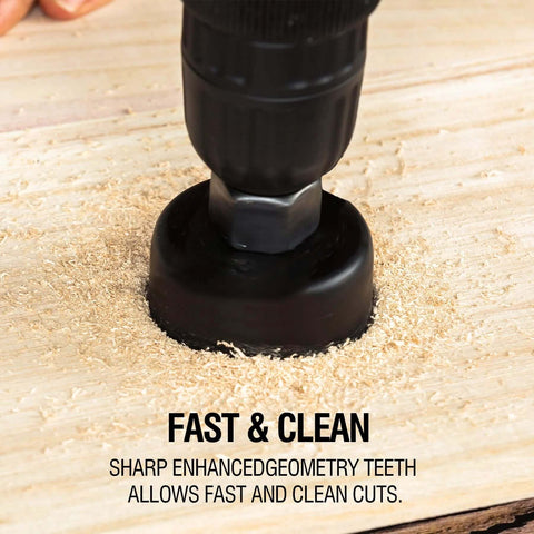 Hole saw bit on a drill cutting into wood, black metal cutter with wood shavings.