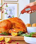 Instant Read Thermapen Inspired Digital Food Thermometer In Cayenne Red checking roast chicken in kitchen setting.