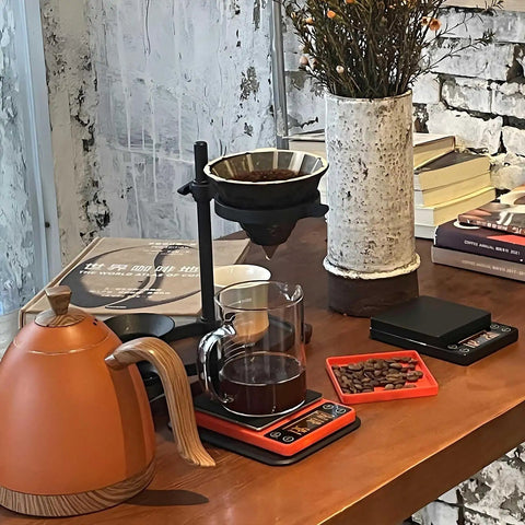 Compact Portable Coffee Scale With Timer 3kg 0.1g High Precision Espresso Scale on table with coffee pot and beans, orange