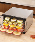 Heavy Duty Five Tray Electric Food Dehydrator With Digital Timer And Temp Control Up To 176 Degrees Fahrenheit filled with sliced fruits.