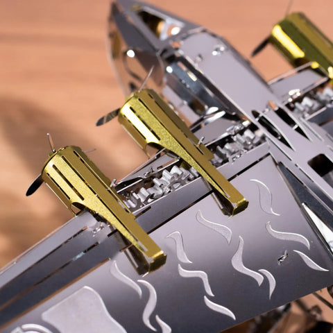 Close-up of Splashing Dreamer 3D Metal Airplane Model Kit With Wind-Up Moving Mechanism, showing metallic wing and gears.