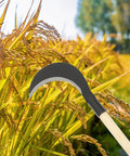 Beefy Long Handle Manganese Steel Hand Scythe for Weeding and Lawn Care Black Half Moon Blade in a field of wheat.