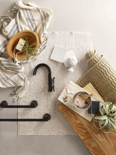Overhead view of Doux Matte Black 24-Inch Single Towel Bar for Bath and Kitchen on a decorative setup with natural elements.