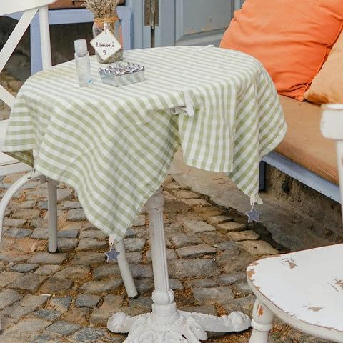 Eight Ounce Tablecloth Weights With Stainless Steel Clips For Outdoor Tables Stay Put Windproof Patio And Picnic Setup Rust Resistant Stone Weights To Keep Cloth Flat In Gusty Weather Gray on a checkered tablecloth on a patio table.