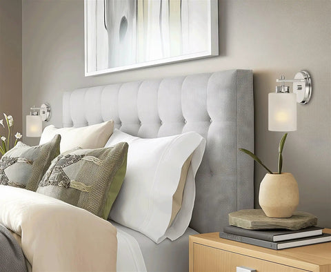 Phoebe 8 Inch Modern Wall Sconce With Frosted Seeded Glass Cylinder Shade In Chrome Finish beside grey tufted headboard
