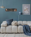 Snag This Sick Vintage Metal Tin Sign Keep It Weird Wall Decor Plaque 4x16 Inches on a blue wall above a cozy couch.