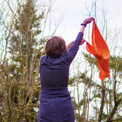 Person holding the Yosemite Map Survival Bandana And Grab-and-Go Emergency Navigation Scarf, Blaze Orange Waterproof Signal Triangle.