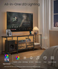 No Sweat Setup Industrial TV Stand With Built In Power Outlets And Chill Led Ambiance Lighting, 70 Inch Media Console For Massive Screens Living Room Storage Shelves Rustic Brown with LED lights and audio equipment.