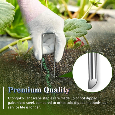 Hand installing Heavy Duty 6 Inch Landscape Staples 11 Gauge Galvanized Garden Stakes into fabric in garden