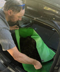 Person placing Beefed Up 3x3 Ft Green Heavy Duty Tarp Waterproof UV Resistant PFAS Free Cover into car trunk
