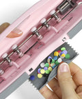 Close-up of pink adjustable 6-hole punch for planners and binders with 8 sheet capacity, showing scrap caddy.