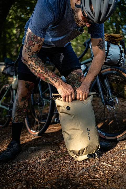 Cyclist securing a Cabezon FB 6 Frame Bag For Bikes, 6L Waterproof Storage Pack For Commuting And All Terrain Riding, outdoors.