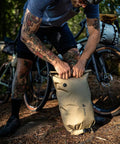 Cyclist fastening 14 Liter Waterproof Handlebar Mounted Bike Bag With Reflective Details And Gear Loops, lightweight for trail ride.