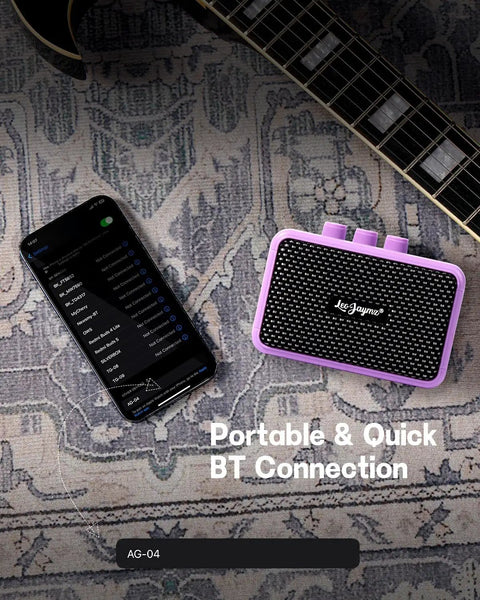 Compact 5W Guitar Amp For On The Go With Dual Speakers Bluetooth Wireless Connectivity Rechargeable Battery Clean And Overdrive Modes Gain Tone And Volume Controls Headphone Jack Ideal For Practice And Small Gigs Purple next to smartphone on rug