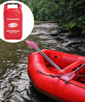 Red WELL-STRONG waterproof first aid kit roll-top bag beside a red inflatable boat with paddles