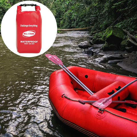 Red WELL-STRONG waterproof first aid kit roll-top bag beside a red inflatable boat with paddles