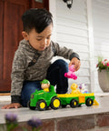 Child playing with Animal Sounds Wagon Ride Musical Tractor Toy Set for Toddlers, Includes Push Along Tractor, Farmer Figure, and 3 Farm Animals