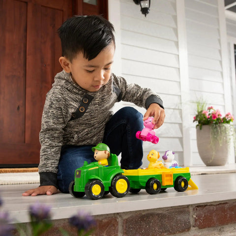 Child playing with Animal Sounds Wagon Ride Musical Tractor Toy Set for Toddlers, Includes Push Along Tractor, Farmer Figure, and 3 Farm Animals