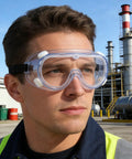 Person wearing two pack white safety goggles, adjustable elastic strap, lightweight PVC frame with anti fog lenses, outdoors.