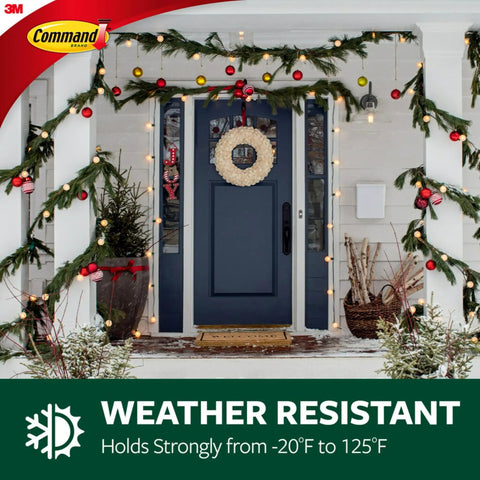 Front door decorated with garland and lights, showcasing Command hooks, 3M logo, weather resistant text, winter scene.