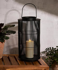 Outdoor Lantern With Realistic LED Candle For Patio, 12 Inch Black Metal Modern Farmhouse Style Lantern on a wooden table